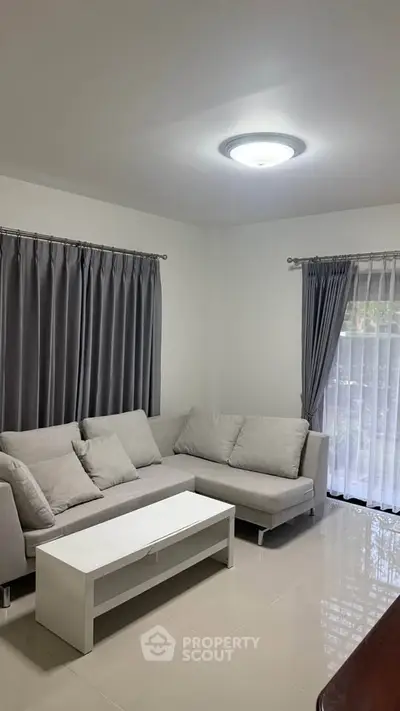 Cozy living room with modern gray sofa and white coffee table, perfect for relaxation.