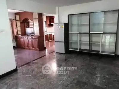 Spacious open-plan living area with modern kitchen and marble flooring