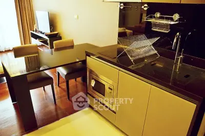 Modern kitchen with sleek black countertops and integrated appliances in stylish apartment.