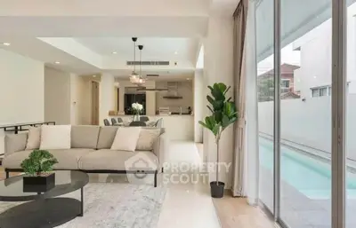 Spacious modern living room with pool view and open kitchen layout