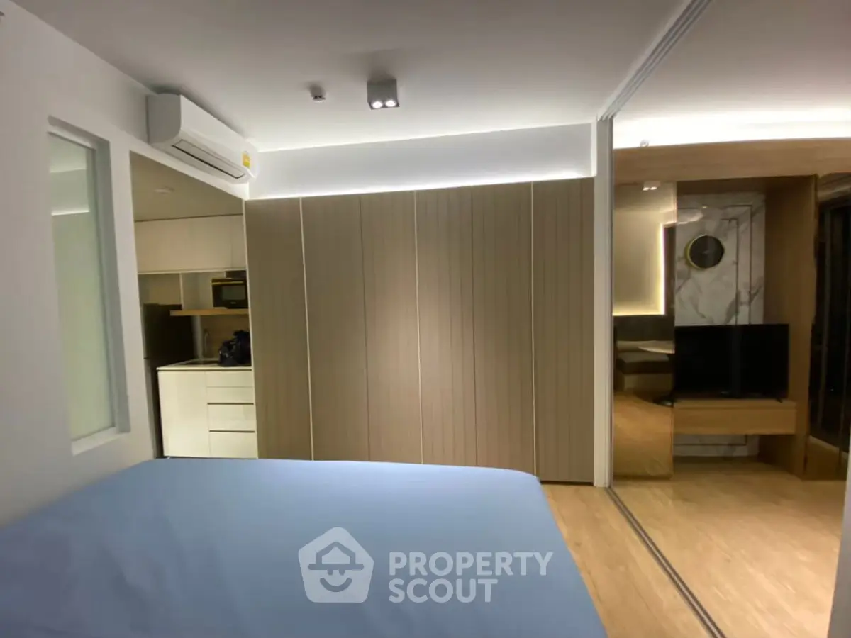 Modern bedroom with sleek design and integrated kitchen area
