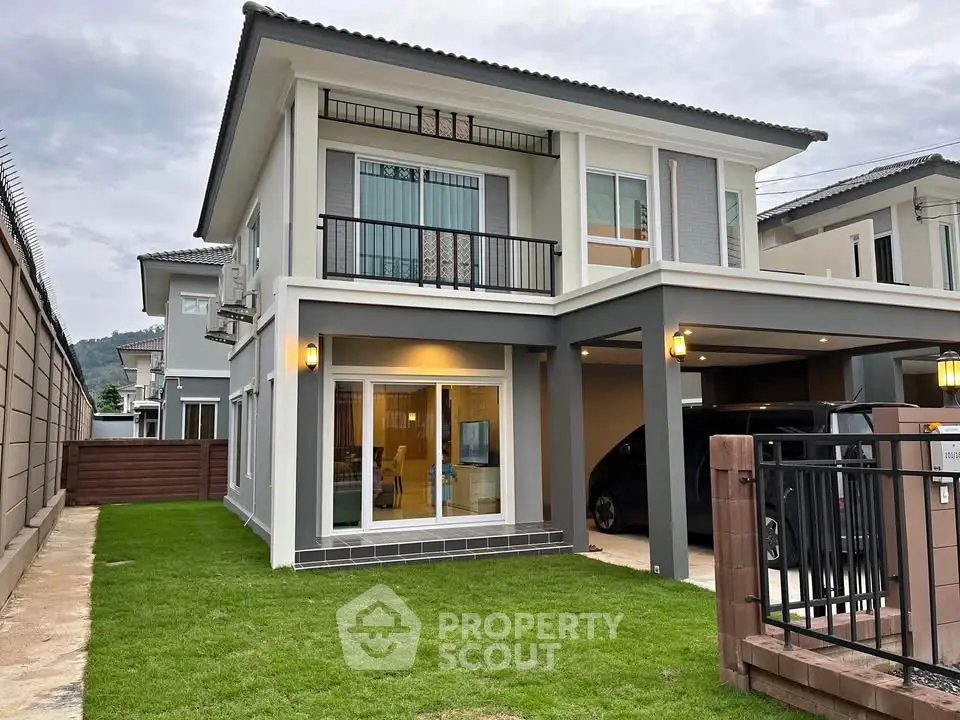 Modern two-story house with a well-maintained lawn and spacious balcony