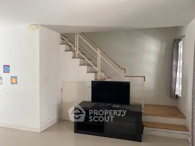 Spacious living room with modern staircase and entertainment unit