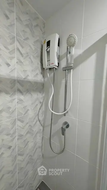 Modern bathroom shower with sleek tile design and water heater unit.