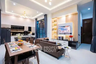 Luxurious open-plan living room and kitchen with modern decor and elegant lighting.