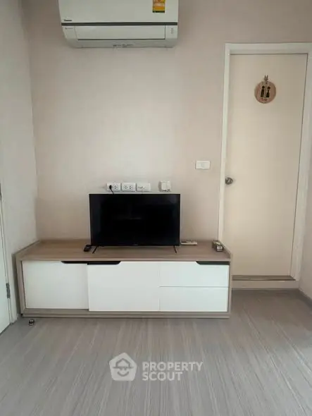 Modern living room with sleek TV stand and air conditioning unit, perfect for cozy relaxation.