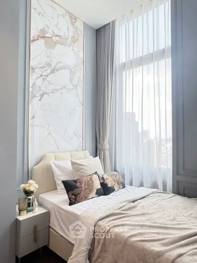 Luxurious bedroom with marble accent wall and large window offering city views.