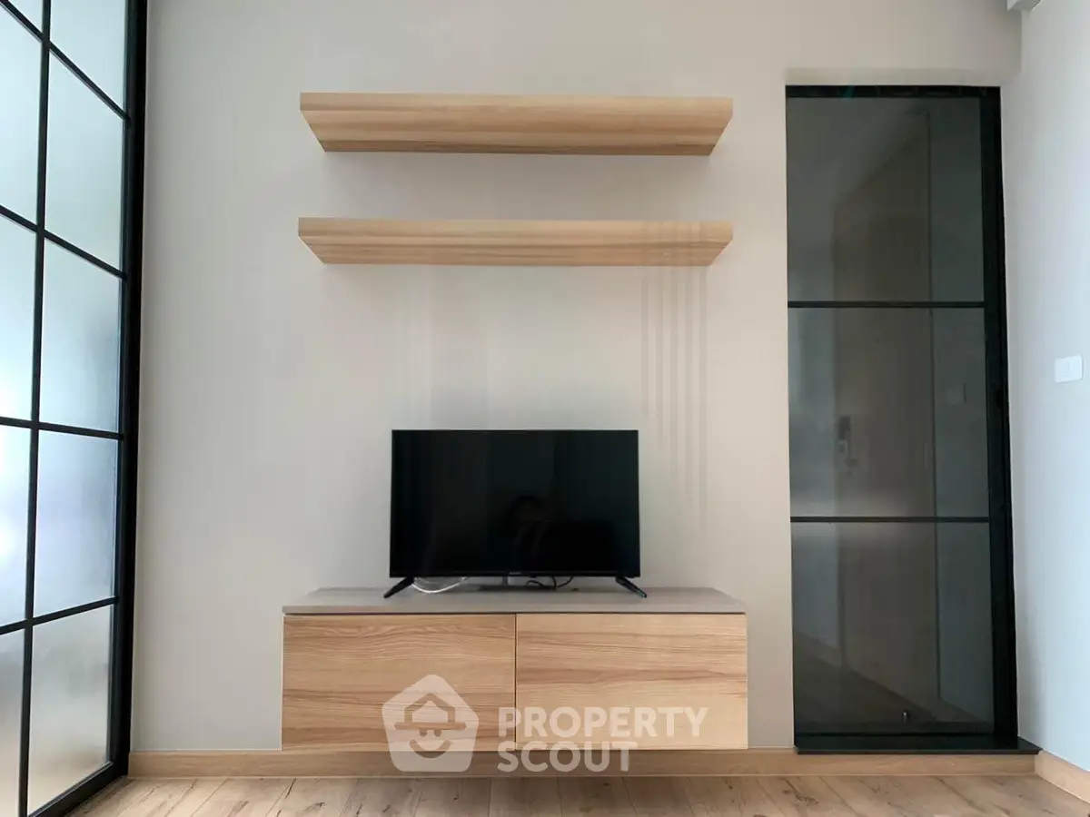 Modern living room with sleek TV stand and floating shelves, featuring minimalist design and natural wood accents.