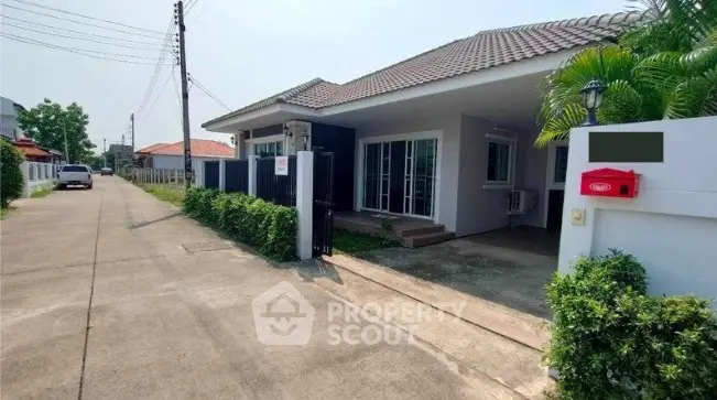 Charming single-story house with driveway and lush greenery in a serene neighborhood.