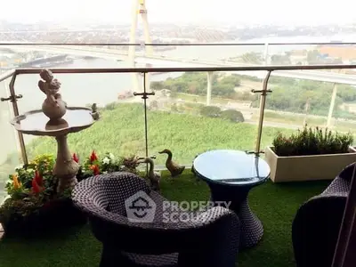 Charming balcony with river view, stylish seating, and lush greenery for a serene outdoor retreat.
