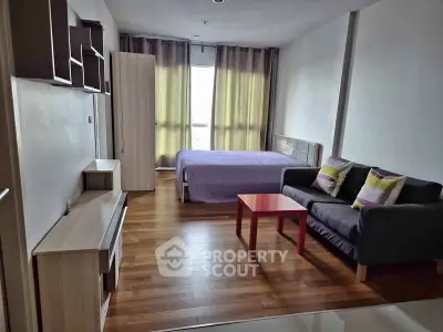 Modern studio apartment with wooden flooring, cozy bed, and stylish sofa in a bright, airy space.