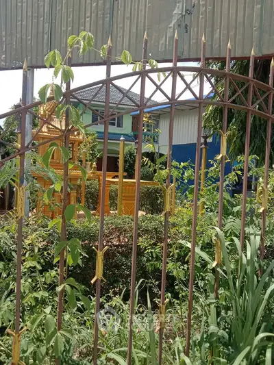 Charming suburban home with lush garden and decorative fence, perfect for nature lovers seeking tranquility.