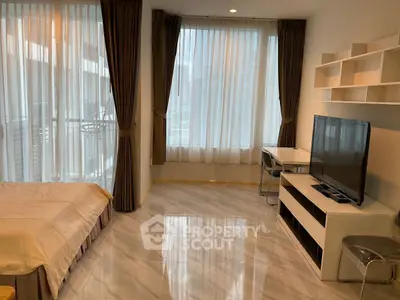 Modern studio apartment with large windows and sleek furnishings in a high-rise building.