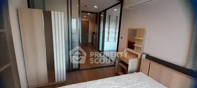 Modern bedroom with wooden furniture and glass partition in a stylish apartment.