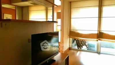 Bright living room with large windows and modern TV setup