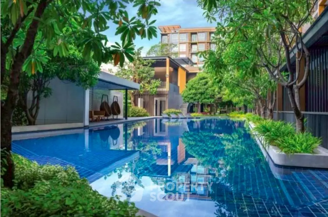 Luxurious residential pool surrounded by lush greenery and modern architecture.