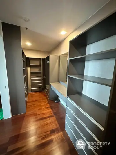 Spacious walk-in closet with modern shelving and hardwood floors