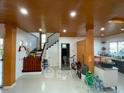 Spacious open-plan living area with modern kitchen and wooden accents, perfect for family gatherings.