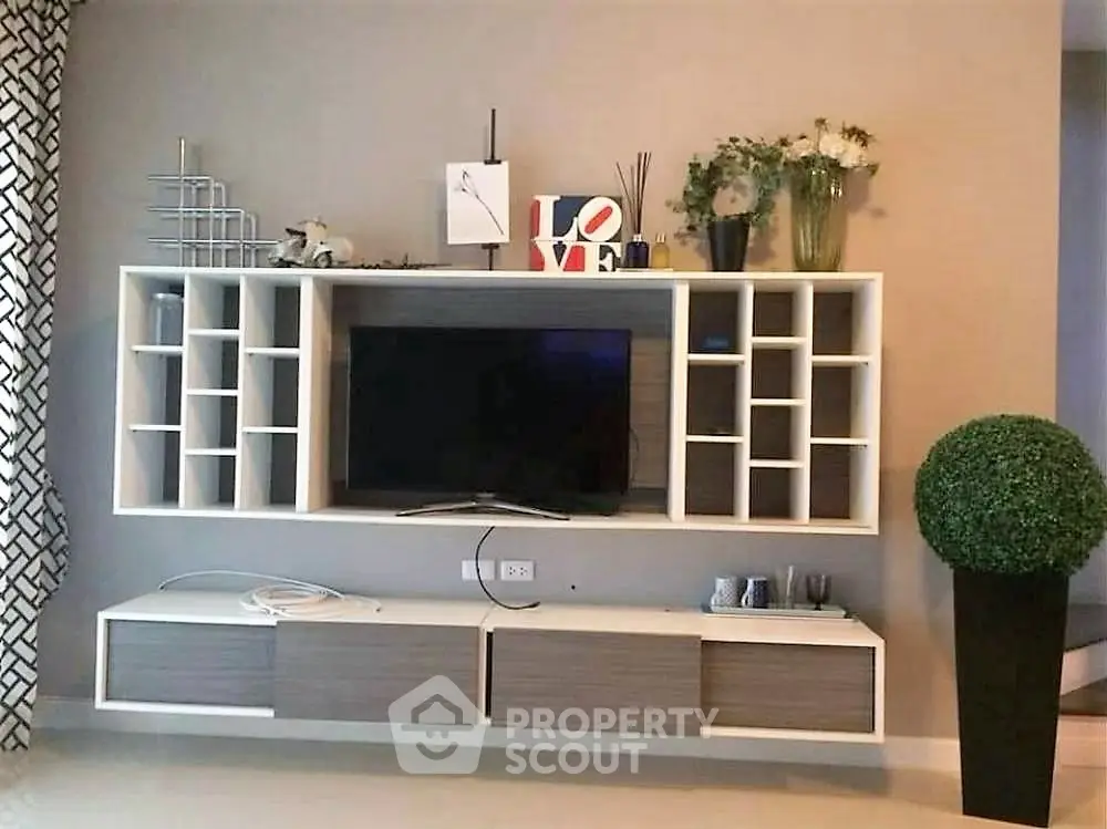 Modern living room with stylish TV unit and decorative shelving