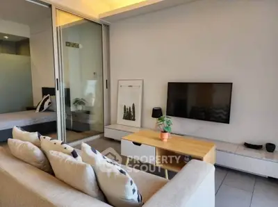 Modern living room with sleek furniture and wall-mounted TV, featuring a cozy ambiance and stylish decor.