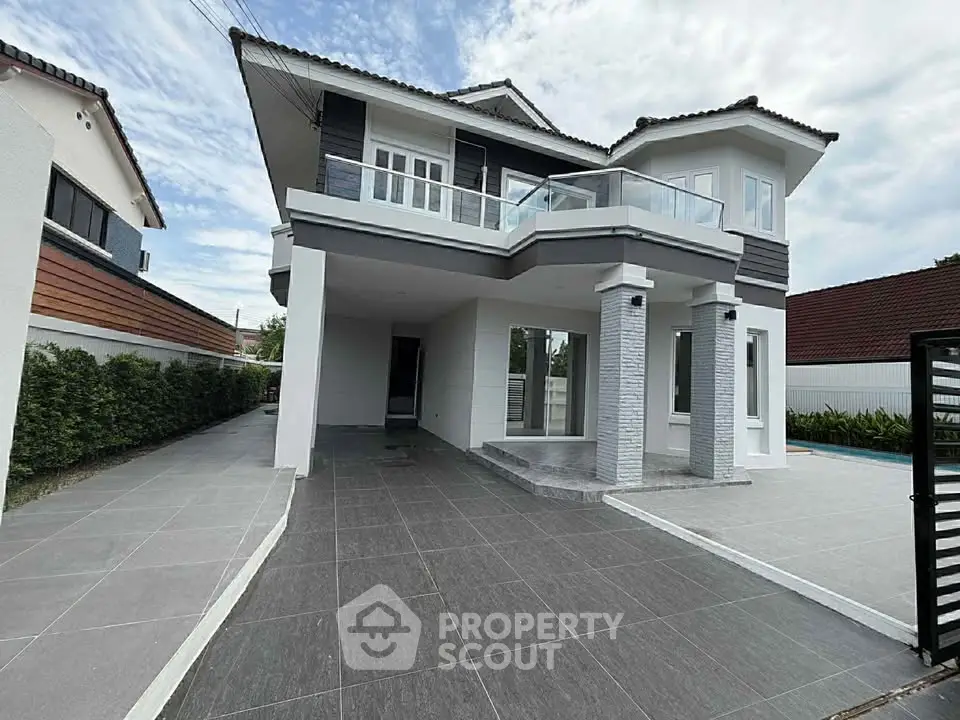 Stunning modern two-story house with spacious driveway and elegant balcony.