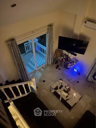 Chic living room with modern decor, large TV, and cozy ambiance, perfect for relaxation and entertainment.