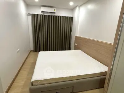 Modern bedroom with minimalist design and air conditioning, featuring a comfortable bed and elegant curtains.