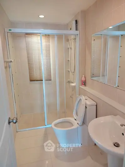 Modern bathroom with glass shower enclosure and sleek fixtures