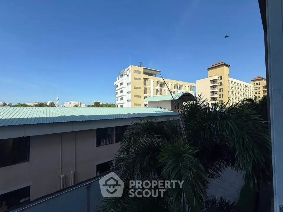 Scenic view of modern residential buildings with lush greenery and clear blue sky.