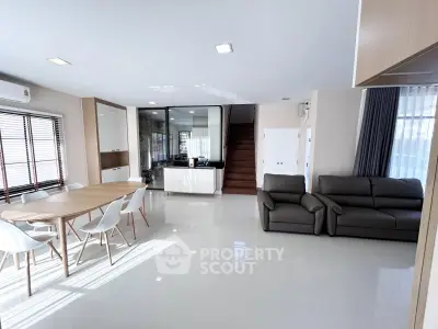 Spacious modern living room with dining area and sleek furniture, perfect for family gatherings.