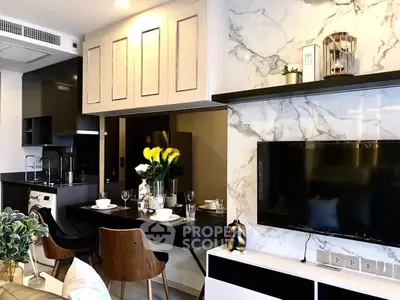 Modern living room with stylish decor, marble accent wall, and open kitchen layout.