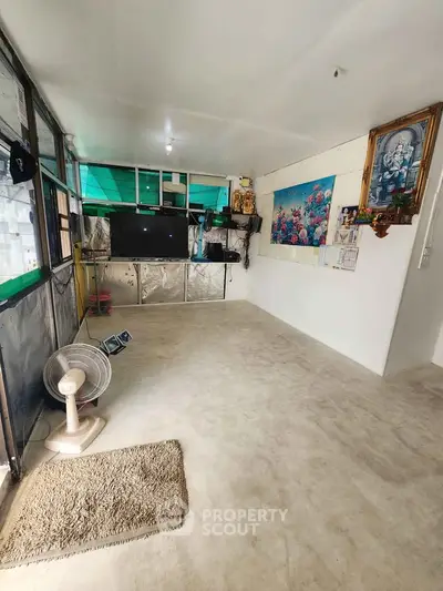 Spacious living room with modern decor and large TV, perfect for relaxation and entertainment.