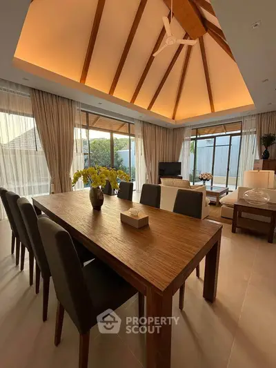 Luxurious open-plan living room with vaulted ceiling and elegant dining area.