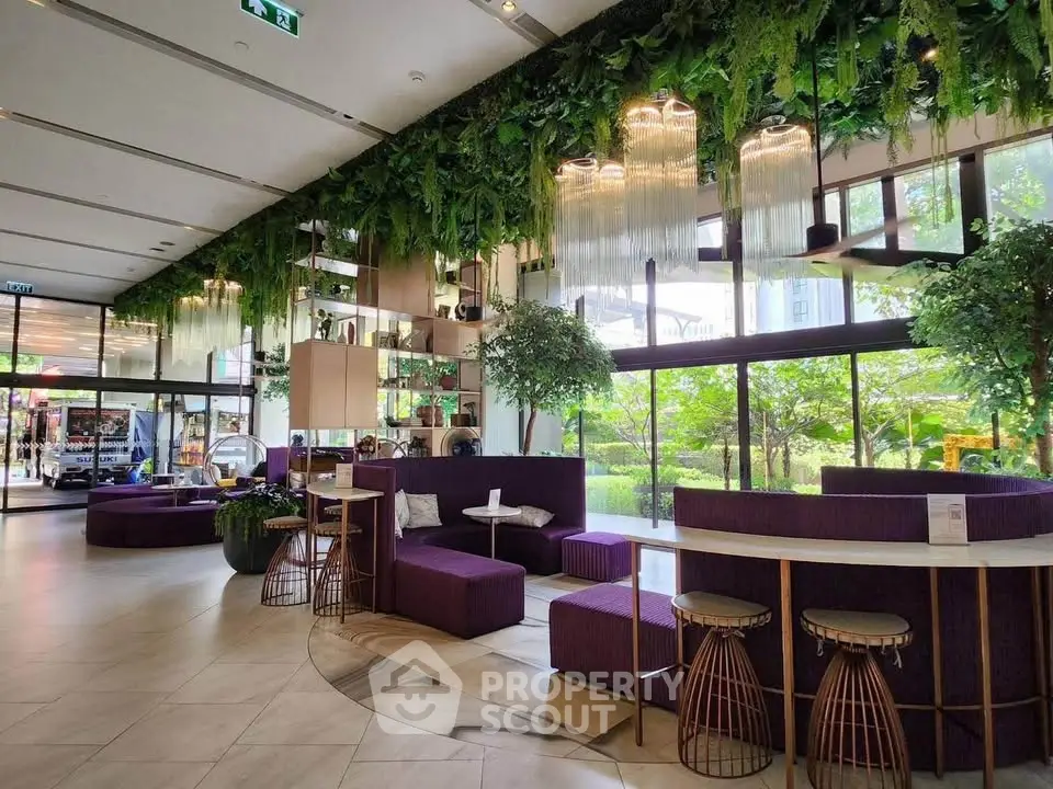 Luxurious modern lobby with lush greenery and stylish seating in a high-end residential building.
