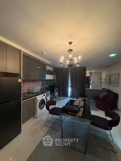Modern kitchen and living area with elegant chandelier and stylish furniture