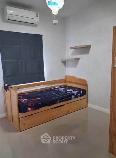 Cozy bedroom with wooden bed and modern air conditioning unit, perfect for a comfortable living space.