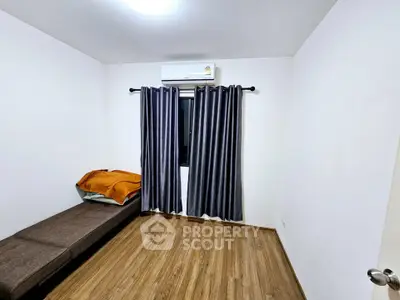 Cozy bedroom with wooden flooring and air conditioning, perfect for a comfortable living experience.