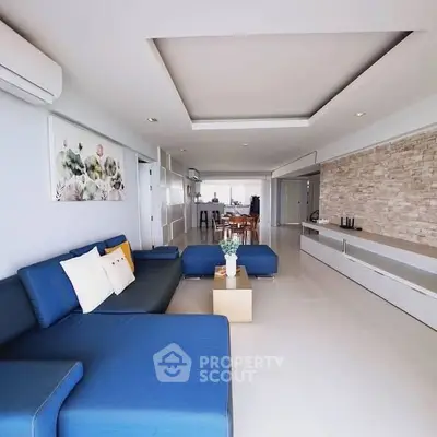 Spacious modern living room with blue sectional sofa and stylish decor