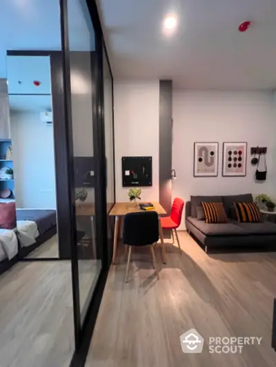 Modern studio apartment with stylish decor, featuring a cozy living area and a sleek glass partition.