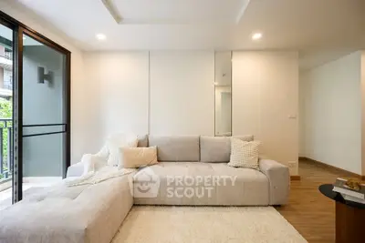 Modern living room with plush sofa and balcony view in a stylish apartment.