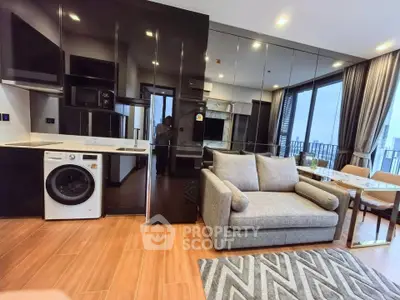 Modern living room with sleek kitchen and washer, featuring floor-to-ceiling windows and stylish decor.