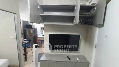 Modern apartment interior with wall-mounted TV and open kitchen layout