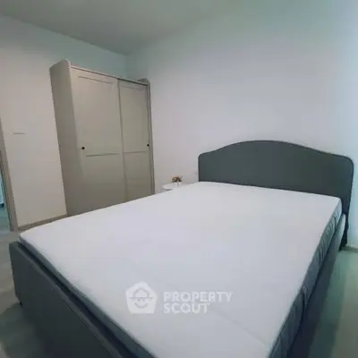 Spacious bedroom with modern bed and wardrobe in a minimalist design.