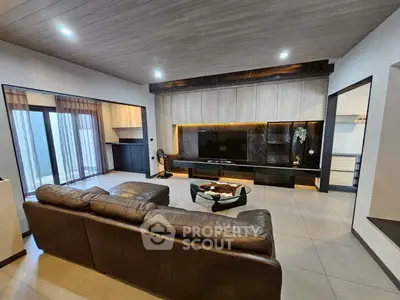 Luxurious modern living room with sleek design and spacious layout, featuring a large leather sofa and stylish decor.