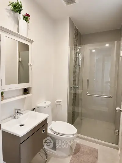 Modern bathroom with sleek shower and elegant vanity in a contemporary home.