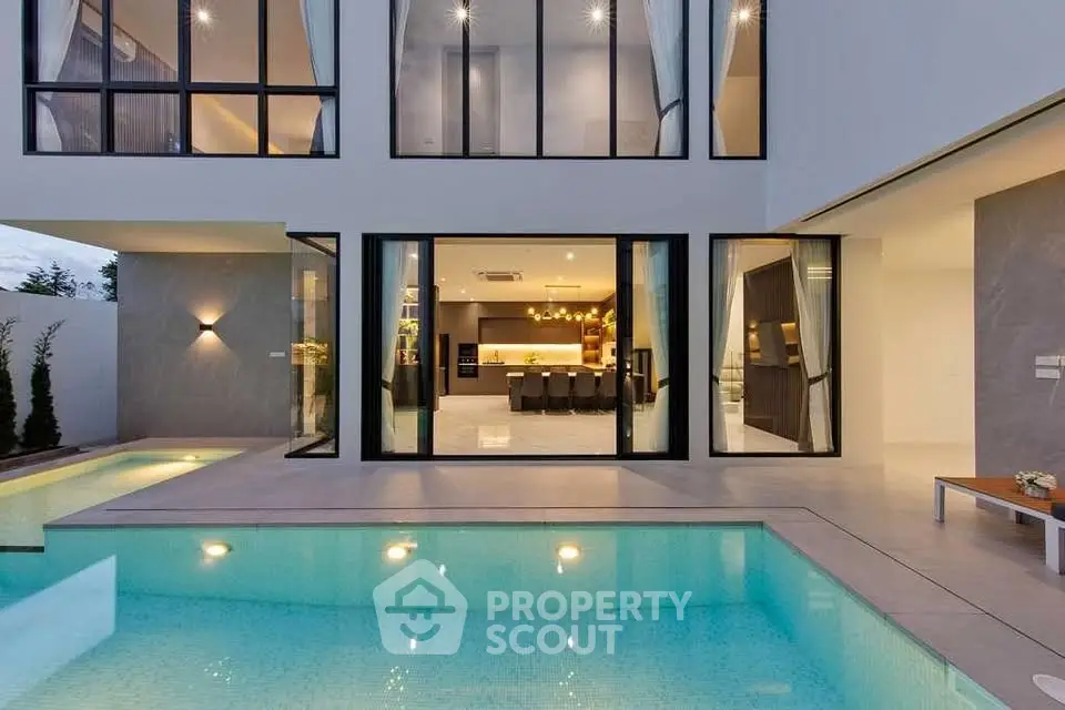 Luxurious modern home with stunning poolside view and elegant interior lighting.