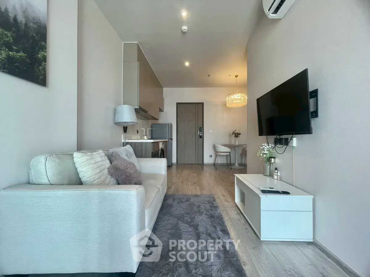 Modern living room with sleek decor and open kitchen layout in a stylish apartment.
