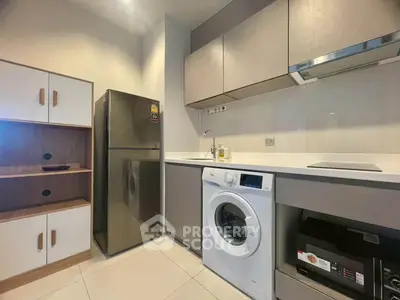 Modern kitchen with sleek cabinets, washing machine, and fridge in a compact layout.