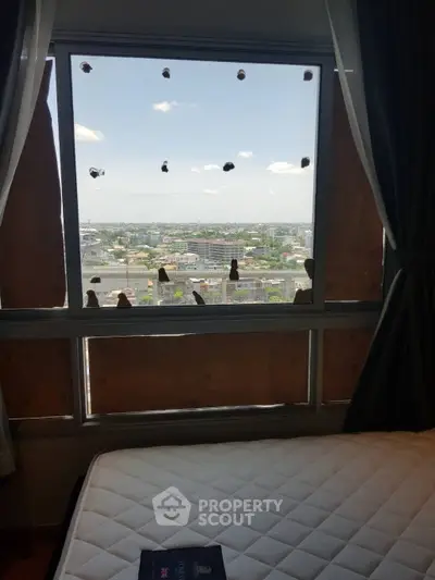 City view from a bedroom window with a mattress in the foreground, offering potential for customization.