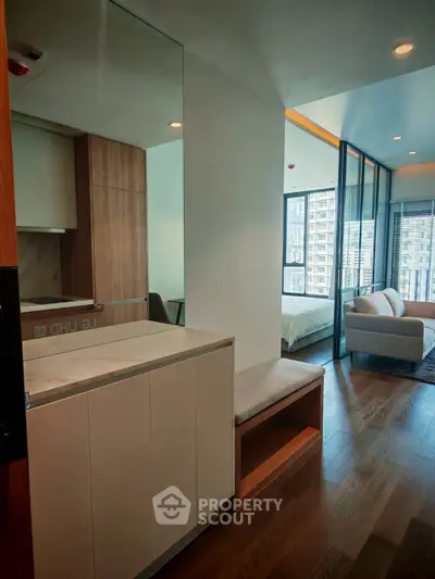 Modern apartment interior with open layout, featuring a cozy living area and bedroom with large windows.